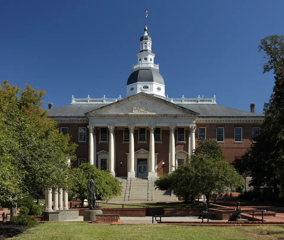 The Maryland State House in Annapolis, a red brick building with a white columned portico and wooden dome.